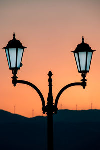 Street light against orange sky