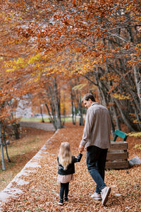 Rear view of woman walking on road