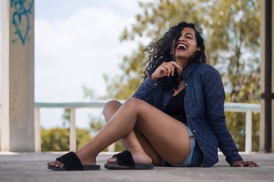 Young woman looking away while sitting outdoors