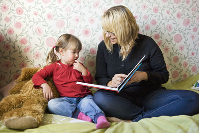 Mother reading book to her daughter