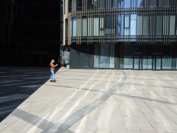 Full length of man walking against building in city