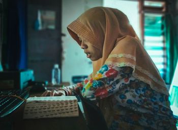 Side view of woman using smart phone at home