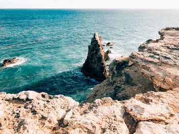 High angle view of rocks in sea against clear sky