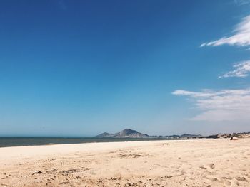 Scenic view of beach against blue sky