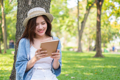 Young woman using mobile phone in park