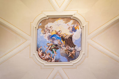 Low angle view of people on ceiling