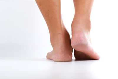 Low section of woman standing against white background