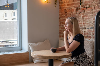 Young woman using mobile phone while sitting at home