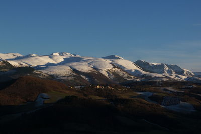 Scenic view of snowcapped mountains against clear sky