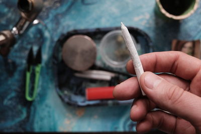 Close-up of hand holding cigarette