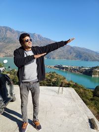 Portrait of young man standing against sky