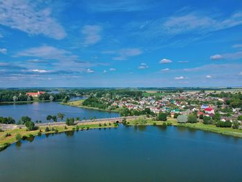 Scenic view of river by city against blue sky