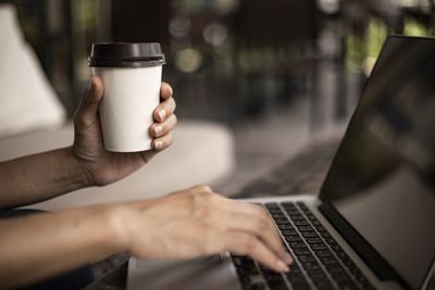 Midsection of person holding coffee cup