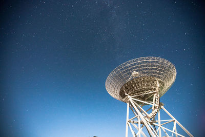 Low angle view of communications tower against clear blue sky