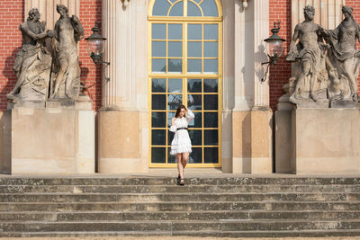 Statue of woman against building