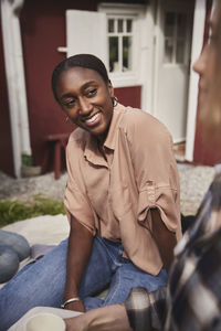 Smiling woman sitting in garden