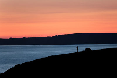 Scenic view of sea against orange sky