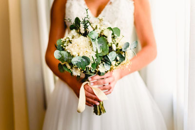 Midsection of woman holding flower bouquet