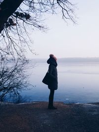 Woman standing on shore against sky