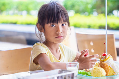 Portrait of cute girl sitting on table