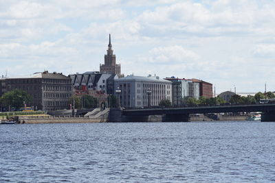 Buildings in city against cloudy sky