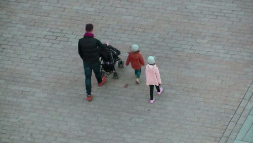 Rear view of men walking on sidewalk