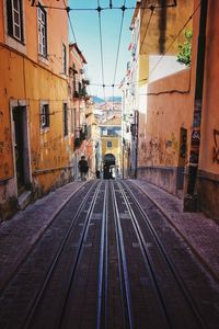 Railroad tracks amidst old buildings in city of lisbon 