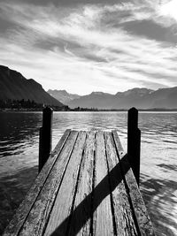 Wooden pier over lake against sky