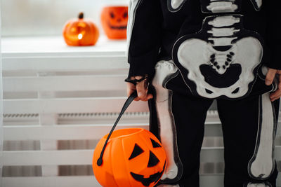 Midsection of woman holding jack o lantern