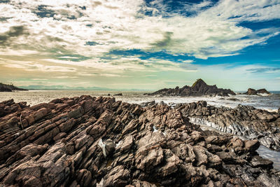 Scenic view of rocks on beach against sky