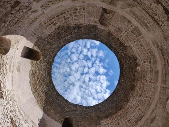 Low angle view of blue sky seen through hole