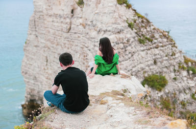 Young people are resting high up the mountain.