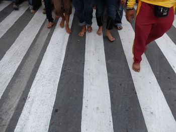 Low section of people walking on road marking