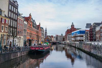 Canal amidst buildings against sky in city