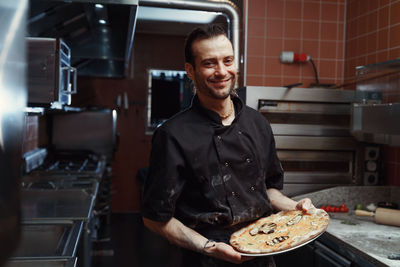 Pizza making process. male chef making authentic pizza in the pizzeria kitchen.