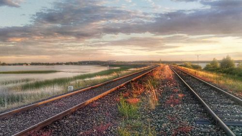 Railway tracks against sky during sunset