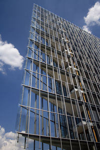 Low angle view of modern building against cloudy sky