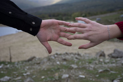 Midsection of couple holding hands