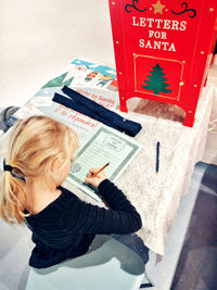 High angle view of woman holding text on paper