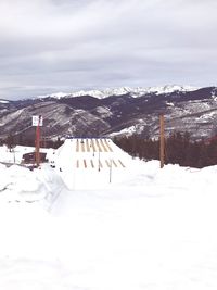 Ski lift over snowcapped mountains against sky