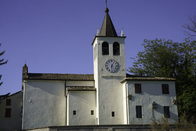 Low angle view of clock tower amidst buildings against sky