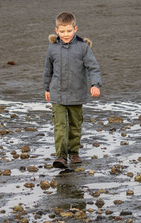 Full length of boy standing in water