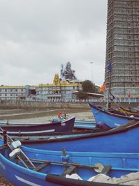 Boats moored in canal against buildings in city