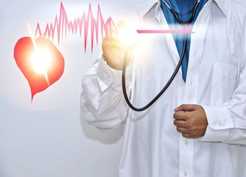 Digital composite image of doctor examining pulse rate with stethoscope