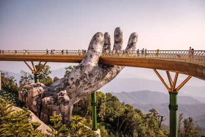 View of birds perching on bridge against clear sky