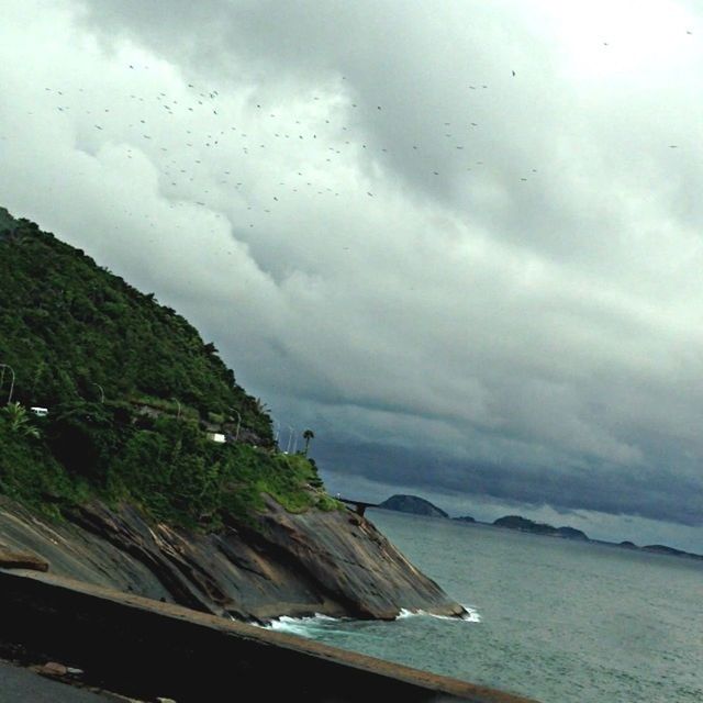 water, sky, cloud - sky, transportation, sea, cloudy, mode of transport, scenics, nature, tranquil scene, beauty in nature, cloud, tranquility, weather, nautical vessel, mountain, day, overcast, boat, travel