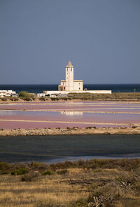 Church building by sea against clear sky in cabo de gata nature park, almeria, spain