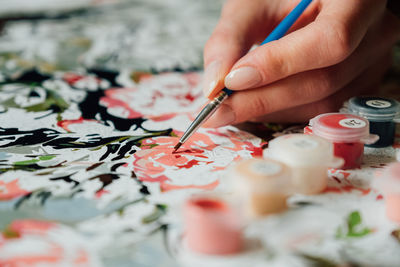 Cropped hands of woman painting