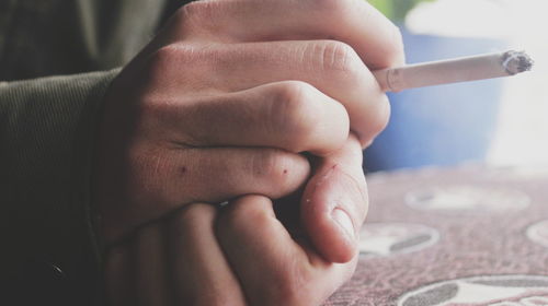 Close-up of hand holding cigarette