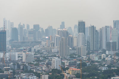 Aerial view of buildings in city against sky